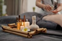 Aromatherapy massage near me—candles, oils, and herbal compress with massage in progress.