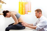Chiropractor for low back pain St Petersburg FL examining patient’s spine during clinical evaluation