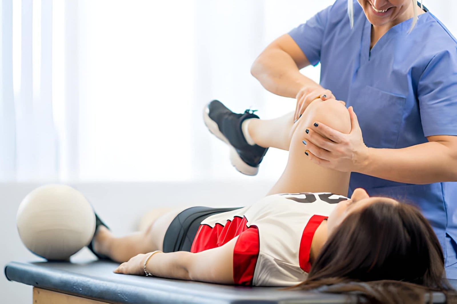Sports injury and physical therapy St Petersburg FL professional assisting patient with knee rehabilitation exercise