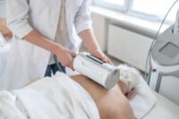 Softwave tissue regeneration technology therapy performed by healthcare professional using handheld device on elderly patient in clinic