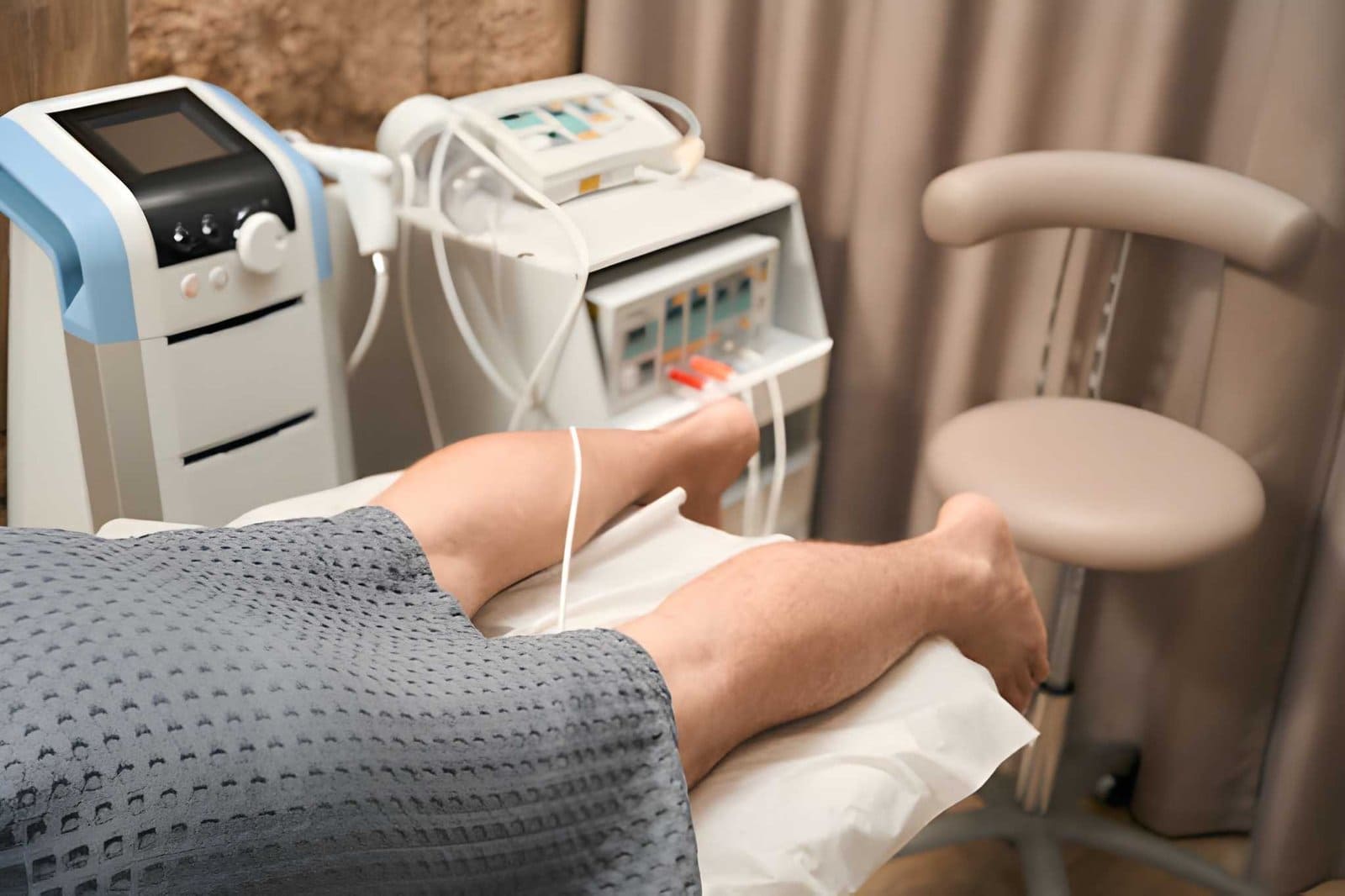 Neuromuscular therapy massage St Petersburg FL patient receiving leg treatment with electrodes and medical devices.