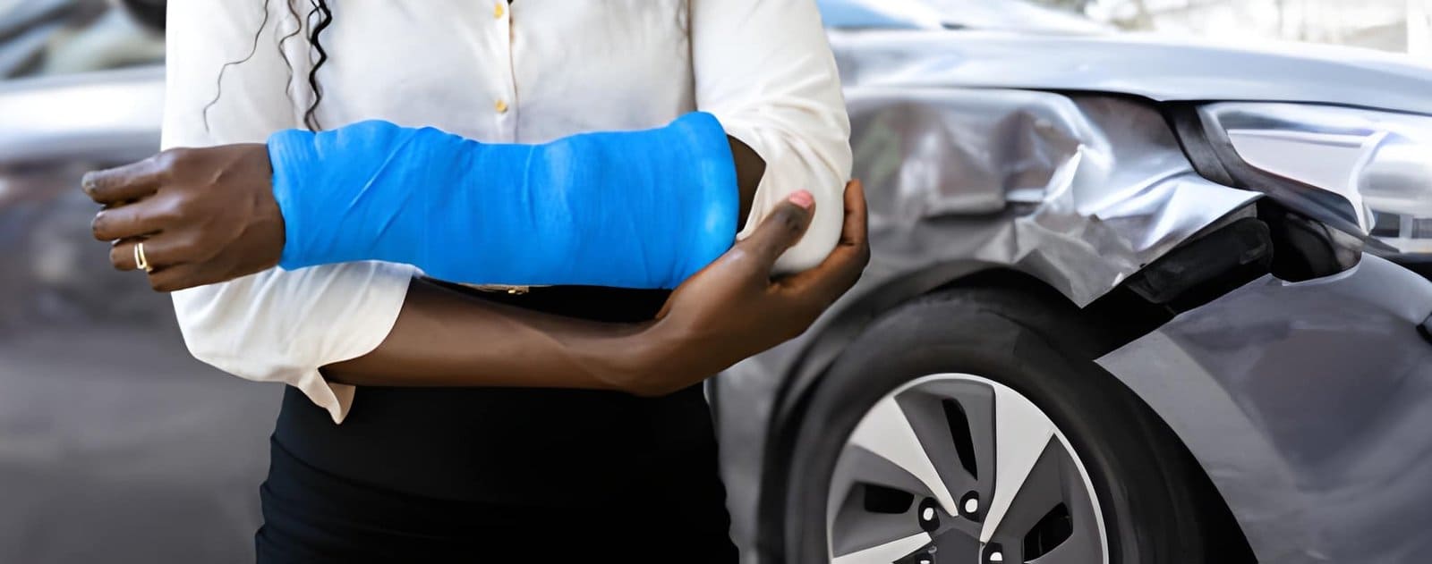 Auto Accident Chiropractor St Petersburg FL patient with arm injury standing near damaged car.