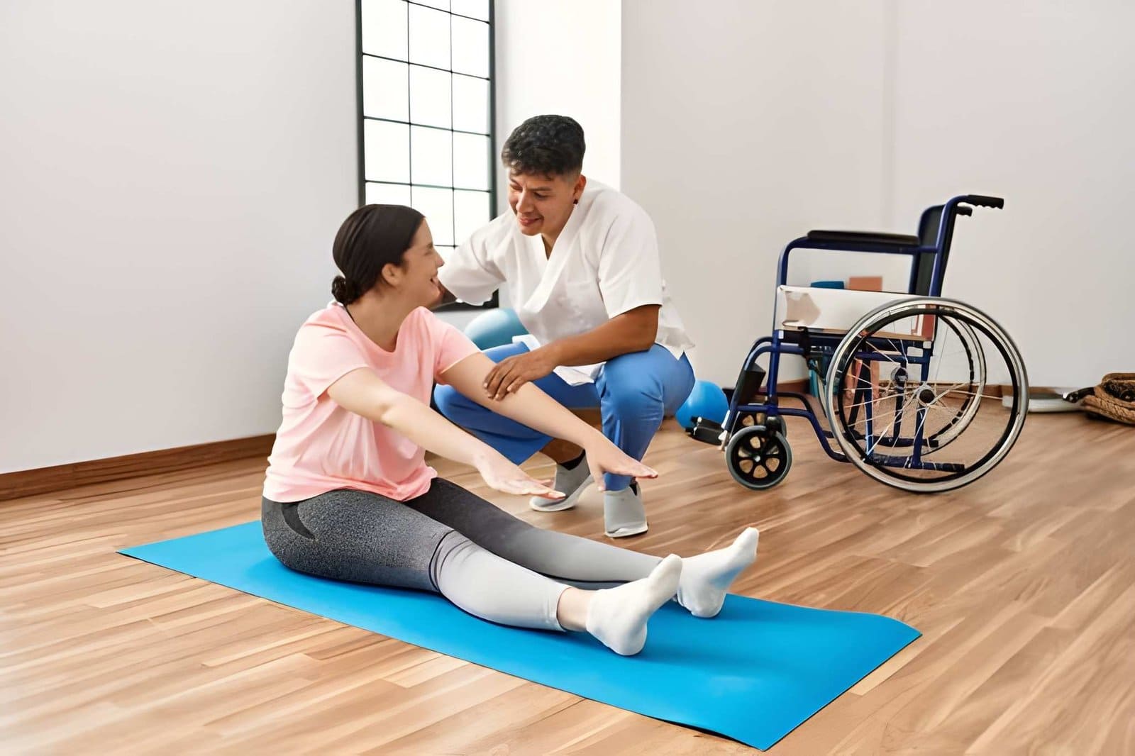 Physical Therapy Clinic in St. Petersburg therapist assisting patient stretching on exercise mat.