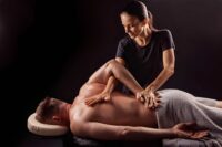 Licensed therapist providing a targeted deep tissue massage St Petersburg FL to a client on a massage table.