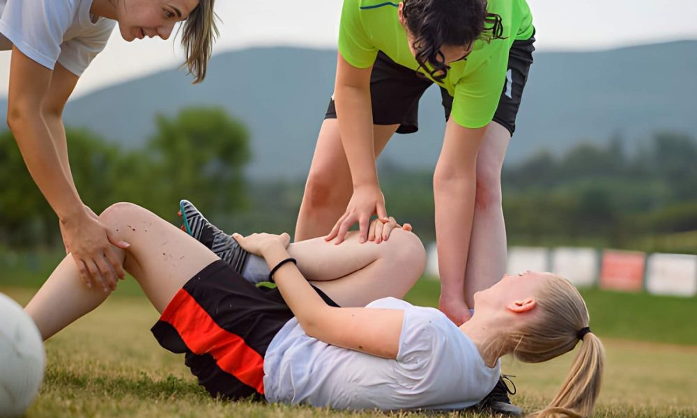 Sports injury and physical therapy St Petersburg FL teammates assisting injured soccer player with leg injury on field