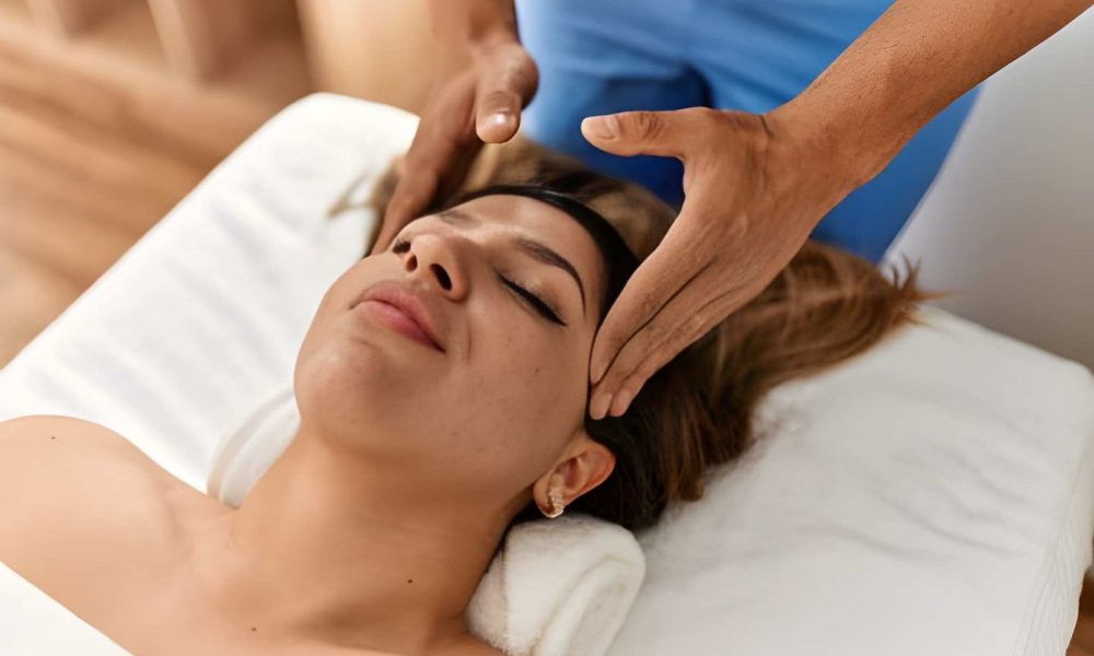 Wellness center St Petersburg FL facial massage therapy with hands gently placed on client’s head for relaxation